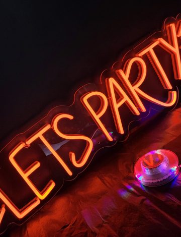 Photo of LED neon sign saying Let's Party with flashes around it