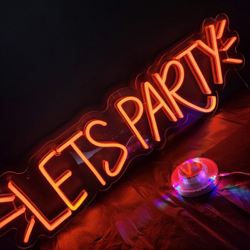 Photo of LED neon sign saying Let's Party with flashes around it