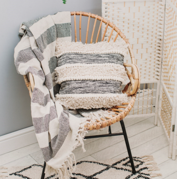 Photo of a striped cushion with throw on a wicker chair