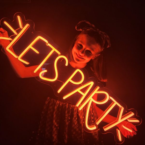Photo of neon sign saying Let's Party with flashes around it