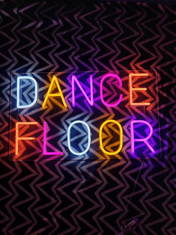 Photo of multicoloured neon sign saying Dance Floor by Love Inc